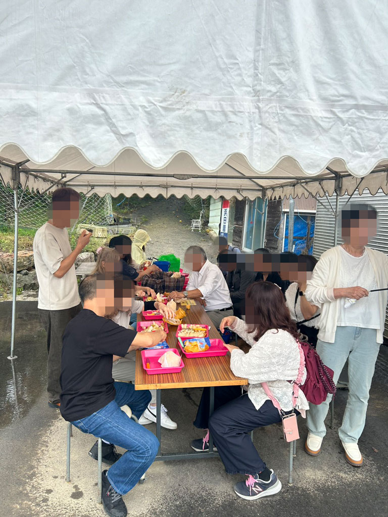 梨狩り農園で収穫した梨を味わうツアー参加者