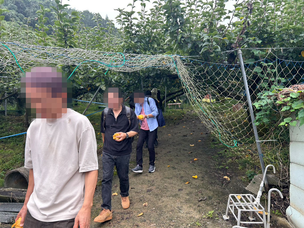 梨狩りを楽しみ収穫した梨を手にするツアー参加者