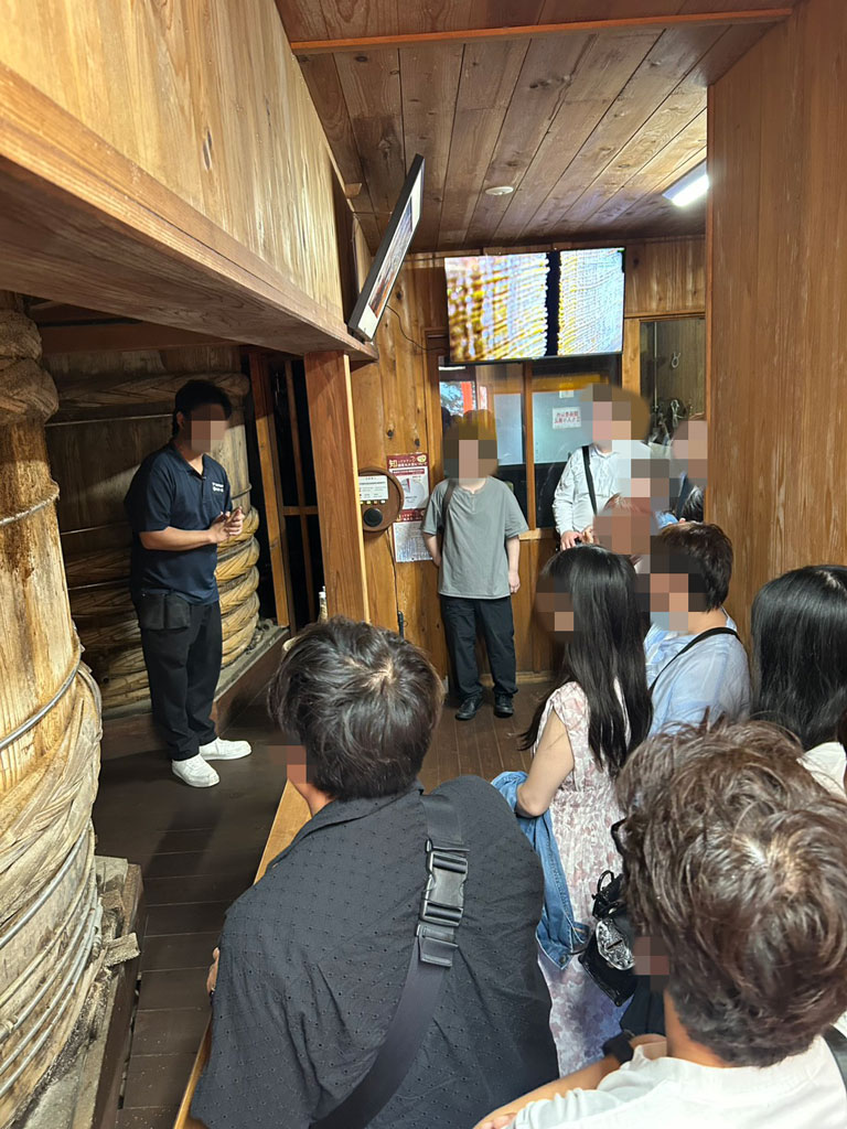湯浅醤油の醤油づくりについて説明を受けるツアー参加者